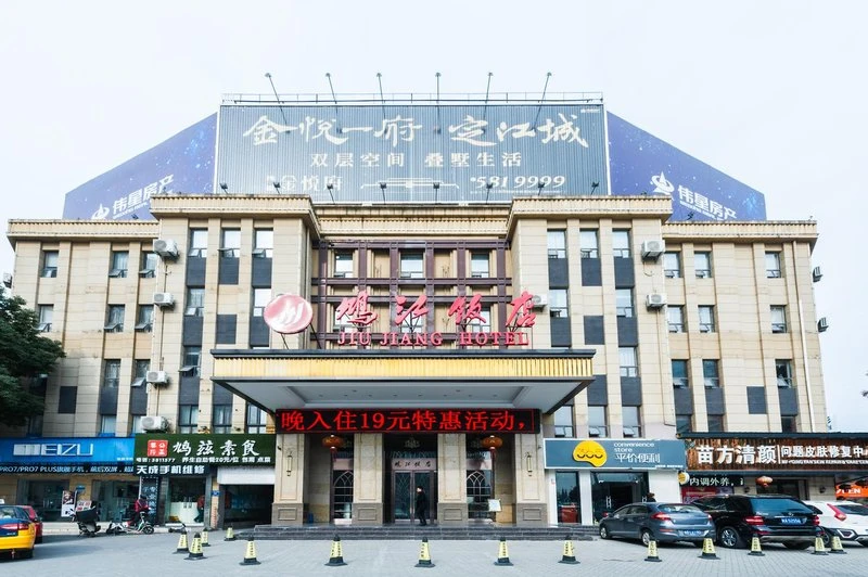 芜湖鸠江饭店公开外观照片：浅色楼体、红色店名、中央雨棚及沿街店面